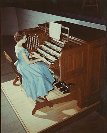 a woman in a blue dress playing the memorial organ