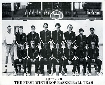 black and white photo of Winthrops first mens basketball team lined up in two rows
                              on the court