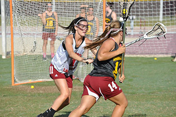 two players on the field during a lacrosse game
