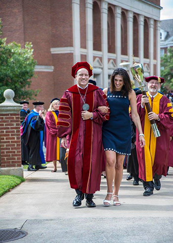 Daniel Mahony, in regalia, and his wife lead the blue line tradition after convocation