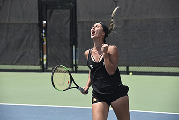 a tennis player celebrates on the court during the ncaa tournament