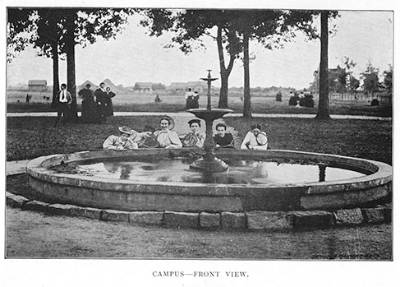 black and white photo of students behind the fountain