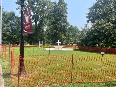 Another angle of the old fountain behind the construction fence. a lamppost with a
                     winthrop banner is visible in the foreground