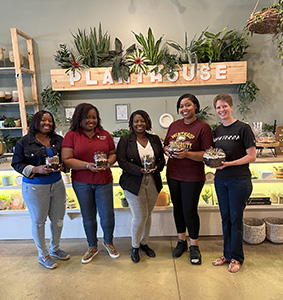 Members of the Columbia Alumni Chapter holding terrariums at PlantHouse
