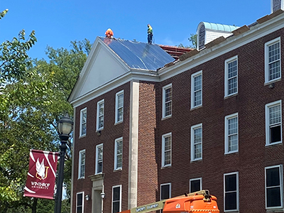 Two people standing on top of residence hall roof