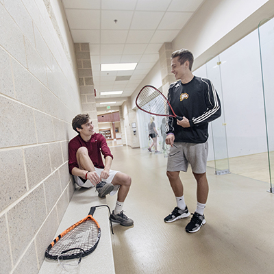 two students outside the racquetball courts in the West Center
