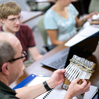 Close-up photo of a teacher showing students a thumb piano