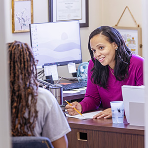 a faculty member talking to a student in her office